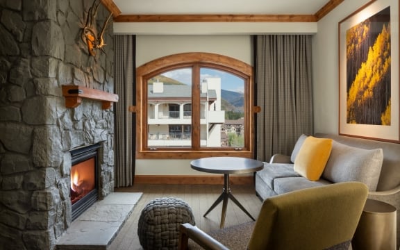 The living room, fireplace, and view from the Jr TImberline Suite from The Hythe Vail CO