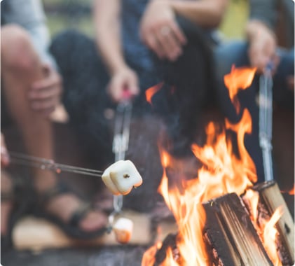 A group of people toasting marshmallows over a fire in Vail CO