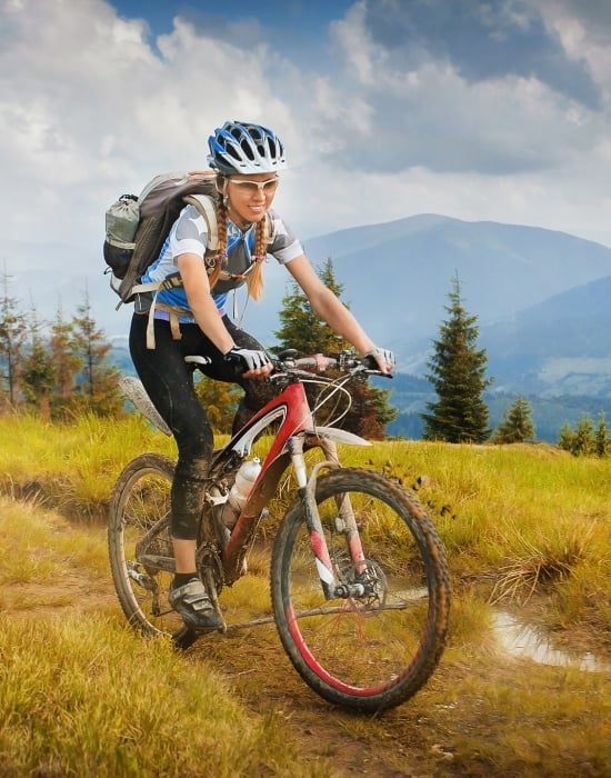A woman mountain biking on a trail in Vail CO