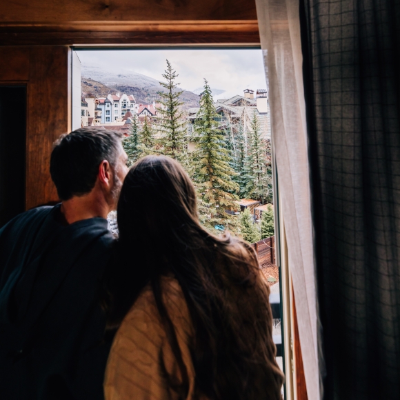 couple looking out of the window of their room